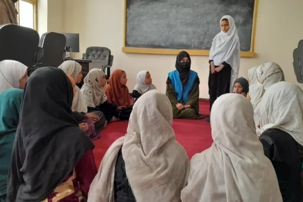 Sahar*, con un grupo de mujeres en Lower Shiekh Mesri School, en Nangarhar, Afganistán, donde da clases de manera voluntaria. © Talwasa Sakhizai/WADAN (socio de ACNUR)