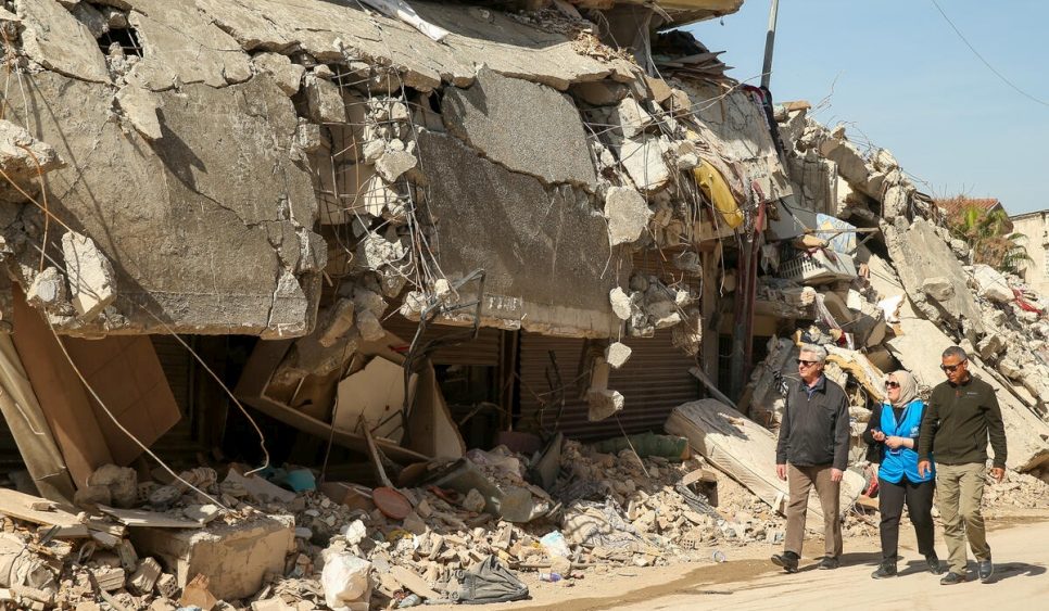 El Alto Comisionado de la ONU para los Refugiados, Filippo Grandi (a la izquierda), camina frente a edificios destruidos en Hatay, Türkiye, durante una visita de tres días al país en marzo. © ACNUR/Emrah Gürel