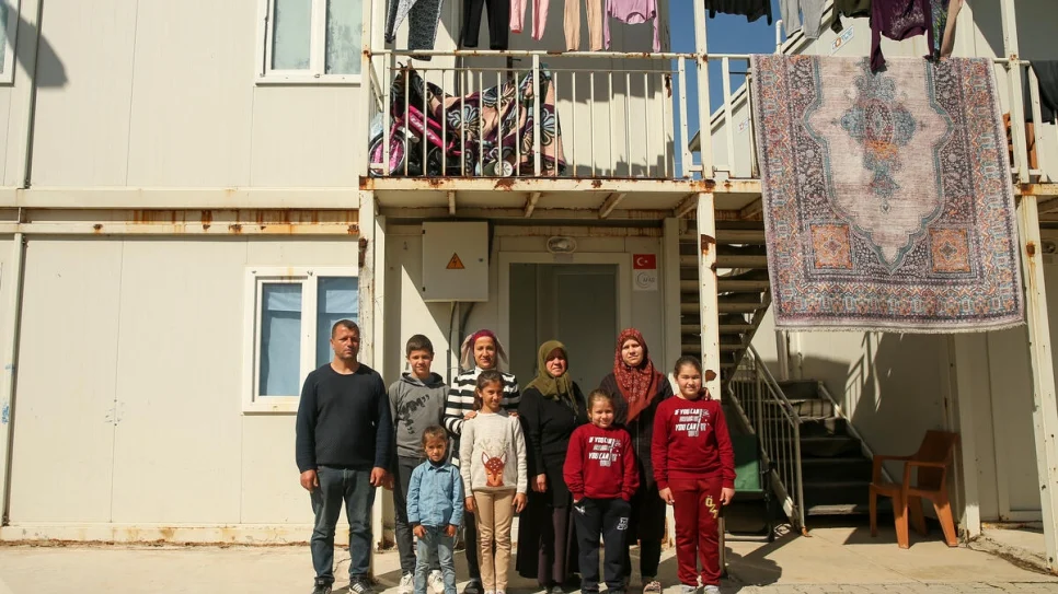La familia Erkan, fuera de sus albergues en el Centro de Alojamiento Temporal de Boynuyoğun, en Hatay, Türkiye. © ACNUR/Emrah Gürel