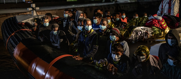 El personal del ACNUR da la bienvenida a 83 refugiados y migrantes procedentes de Bangladesh, Burkina Faso, Somalia, Marruecos, Egipto, Libia y Pakistán tras desembarcar en el puerto de Lampedusa por la noche en año 2020 © UNHCR/Alessio Mamo