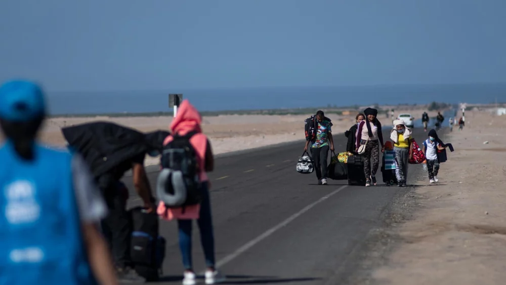 Familias venezolanas recorren una carretera paralela a la frontera con Chile, en la región de Tacna, al sur de Perú (3 de diciembre de 2021). © ACNUR/Raul Garcia Pereira