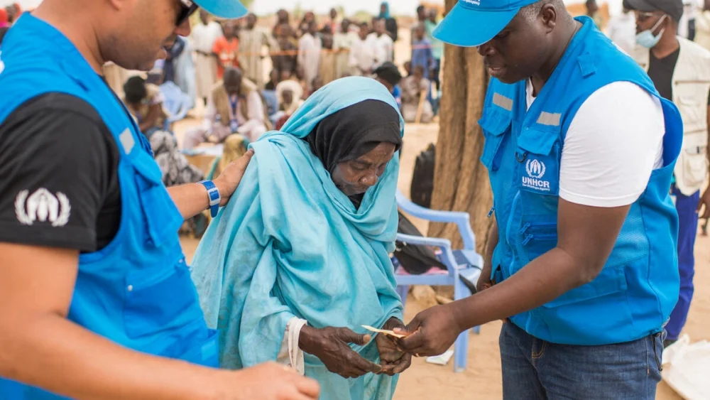 La refugiada sudanesa Khadija Mahamat, de 72 años, es asistida por personal de ACNUR en el asentamiento de Madjigilta, en la región chadiana de Ouaddaï, en la frontera con Sudán. © ACNUR/Colin Delfosse