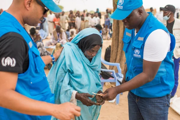 La refugiada sudanesa Khadija Mahamat, de 72 años, es asistida por personal de ACNUR en el asentamiento de Madjigilta, en la región chadiana de Ouaddaï, en la frontera con Sudán. © ACNUR/Colin Delfosse