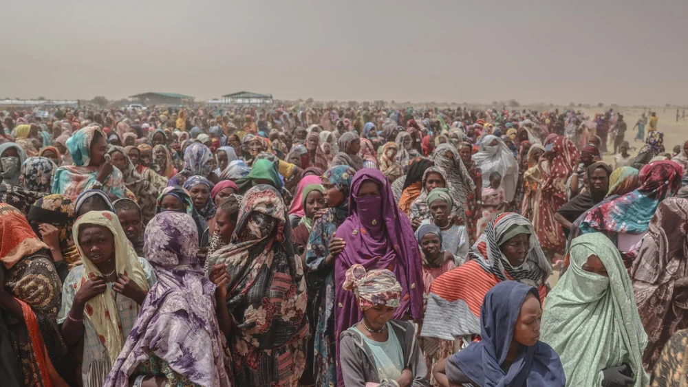 Miles de refugiados recién llegados desde la región de Darfur Norte, en Sudán, esperan por alimentos cerca del cruce fronterizo de Tiné, en Chad. © ACNUR/Caitlin Kelly