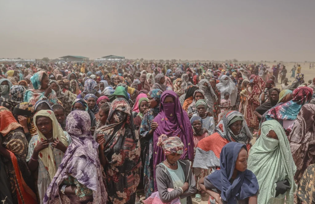 Miles de refugiados recién llegados desde la región de Darfur Norte, en Sudán, esperan por alimentos cerca del cruce fronterizo de Tiné, en Chad. © ACNUR/Caitlin Kelly