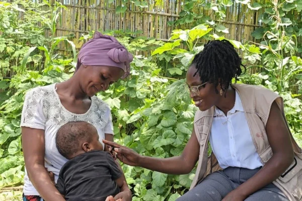 A la puerta de su casa en Cabo Delgado, la psicóloga Ancila Niyubuntu comparte un momento de alegría con Viaze Abudo, una de las mujeres a las que ha apoyado.