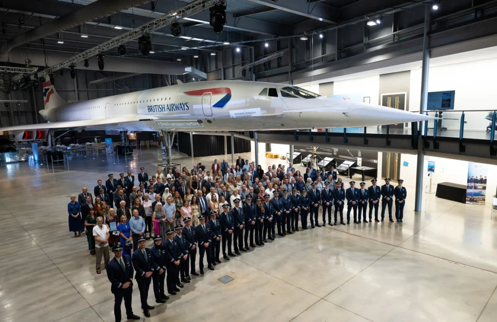 Los asistentes a una ceremonia de certificación de pilotos de la aerolínea TUI posan delante de un avión Concorde en Aerospace Bristol, Reino Unido. © ACNUR/LivPix Photography