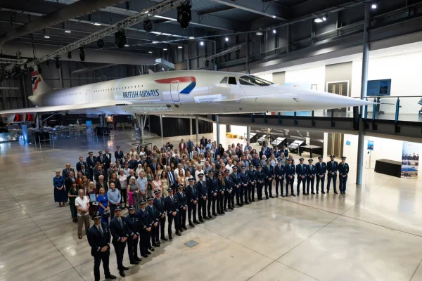 Los asistentes a una ceremonia de certificación de pilotos de la aerolínea TUI posan delante de un avión Concorde en Aerospace Bristol, Reino Unido. © ACNUR/LivPix Photography