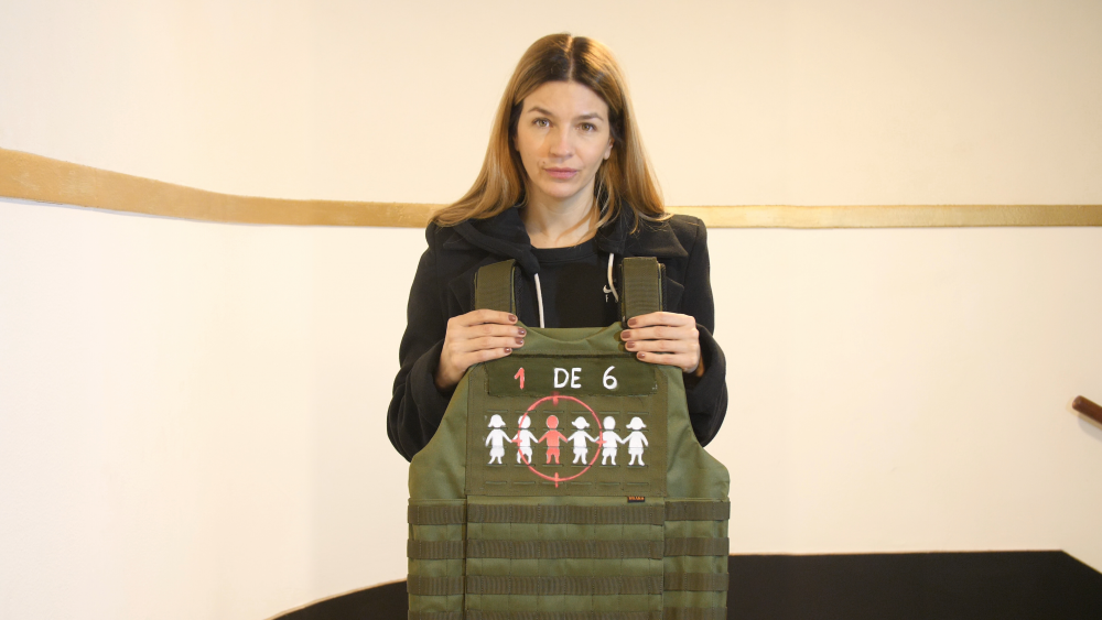 Marcela Kloosterboer sostiene un chaleco antibalas como parte de la campaña “La guerra no es un juego” de Fundación ACNUR Argentina, que busca visibilizar la realidad de millones de niños y niñas afectados por la guerra y el desplazamiento forzado.