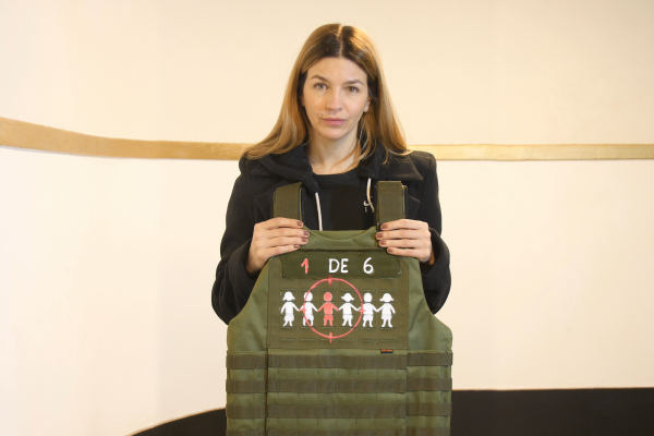 Marcela Kloosterboer sostiene un chaleco antibalas como parte de la campaña “La guerra no es un juego” de Fundación ACNUR Argentina, que busca visibilizar la realidad de millones de niños y niñas afectados por la guerra y el desplazamiento forzado.