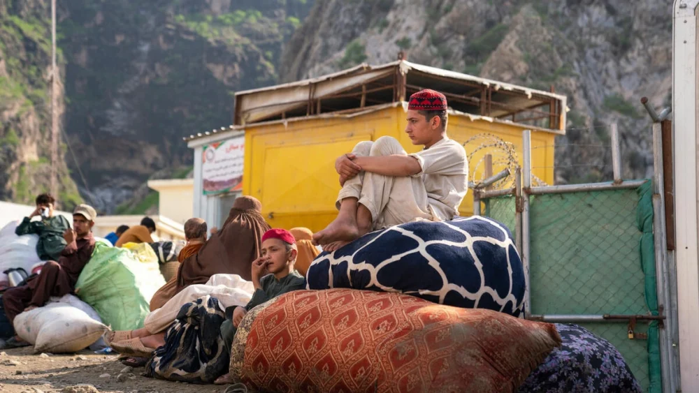 Ahmad, de 15 años, y su hermano pequeño Sahil, de 12, esperan en la frontera de Torkham entre Pakistán y Afganistán con su familia, tras retornar desde Pakistán. © ACNUR/Oxygen Empire Media Production
