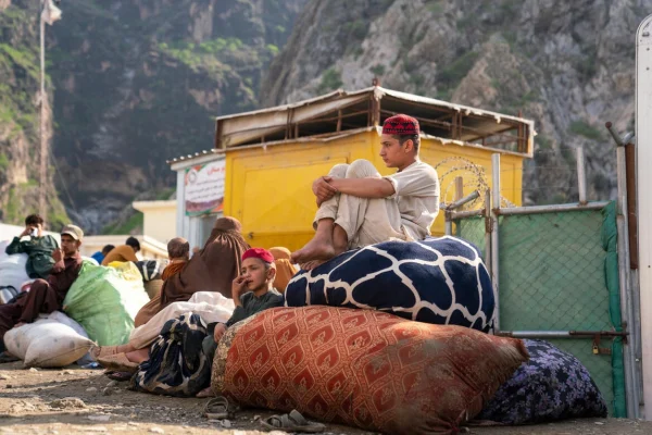 Ahmad, de 15 años, y su hermano pequeño Sahil, de 12, esperan en la frontera de Torkham entre Pakistán y Afganistán con su familia, tras retornar desde Pakistán. © ACNUR/Oxygen Empire Media Production