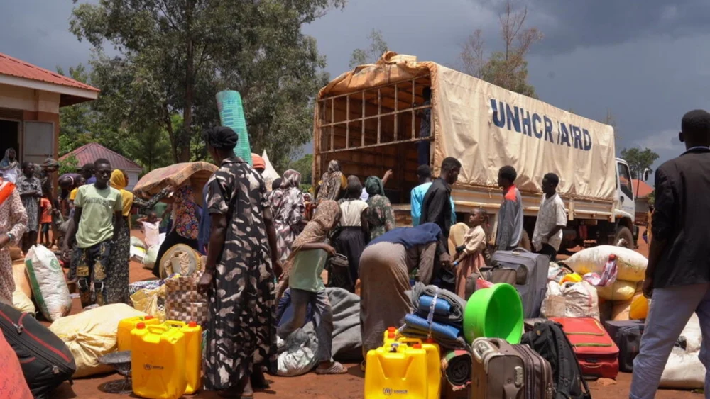 Personas sudanesas recién llegadas descargan su equipaje de un camión de ACNUR en el Centro de Recepción de Kiryandongo, al noroeste de Uganda. © ACNUR/Ssozi Mukasa Daniel
