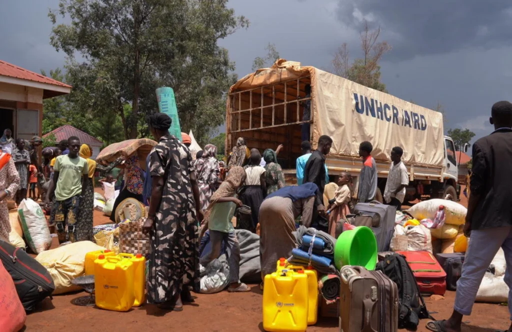 Personas sudanesas recién llegadas descargan su equipaje de un camión de ACNUR en el Centro de Recepción de Kiryandongo, al noroeste de Uganda. © ACNUR/Ssozi Mukasa Daniel