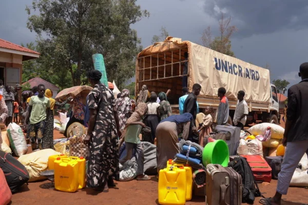 Personas sudanesas recién llegadas descargan su equipaje de un camión de ACNUR en el Centro de Recepción de Kiryandongo, al noroeste de Uganda. © ACNUR/Ssozi Mukasa Daniel