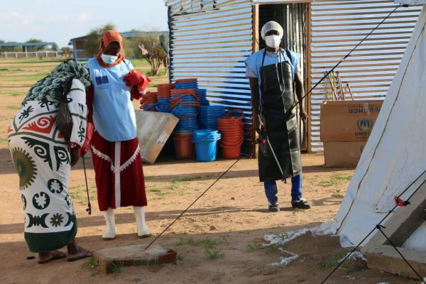 Trabajadores sanitarios en el asentamiento de refugiados de Dougui, en el este de Chad, desinfectan locales e instalaciones de kits de lavado de manos para limitar la cadena de contaminación por cólera. © ACNUR/Bockarie Kallon