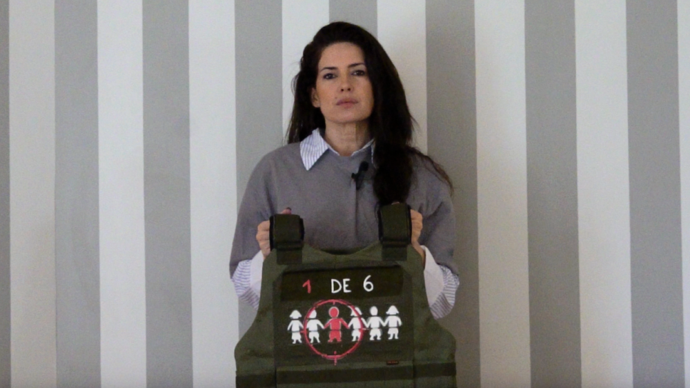 Isabel Macedo sostiene un chaleco antibalas como parte de la campaña “La guerra no es un juego” de Fundación ACNUR Argentina, que busca visibilizar la realidad de millones de niños y niñas afectados por la guerra y el desplazamiento forzado.