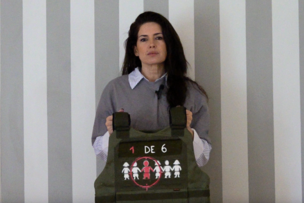 Isabel Macedo sostiene un chaleco antibalas como parte de la campaña “La guerra no es un juego” de Fundación ACNUR Argentina, que busca visibilizar la realidad de millones de niños y niñas afectados por la guerra y el desplazamiento forzado.