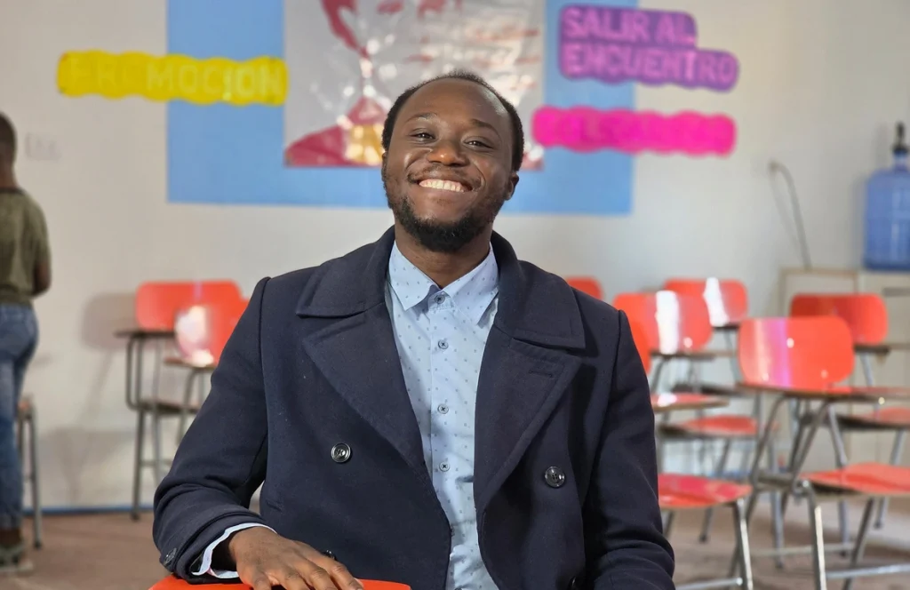 Ralph Jean Baptiste sonríe en la sala de clases, donde cada palabra se convierte en un puente de integración y esperanza para su comunidad haitiana en Chile. © ACNUR/Stephanie Rabi