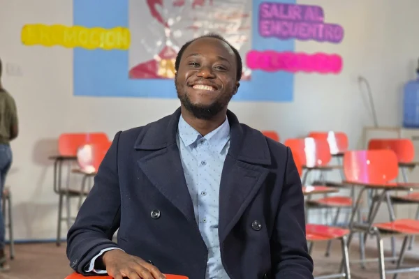 Ralph Jean Baptiste sonríe en la sala de clases, donde cada palabra se convierte en un puente de integración y esperanza para su comunidad haitiana en Chile. © ACNUR/Stephanie Rabi