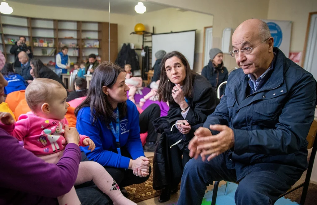 El Alto Comisionado de la ONU para los Refugiados, Barham Salih (a la derecha), habla con Nina (a la izquierda) en un centro de tránsito en Zaporizhzhia, al sureste de Ucrania, después de que ella fuera evacuada de su casa dañada por las bombas junto con su hija y sus tres nietos. © ACNUR/Nikola Ivanovski