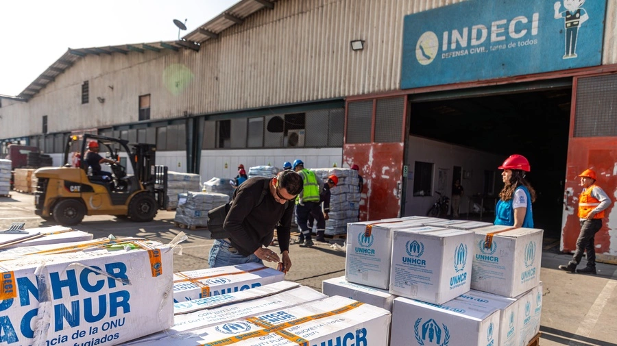 Personal del Instituto Nacional de Defensa Civil (INDECI) descarga parte de la ayuda humanitaria donada por ACNUR en uno de sus almacenes situado en el Callao, Perú. © ACNUR/Jaime Giménez
