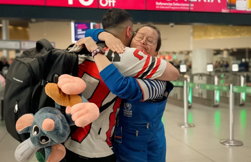 Refugiado venezolano se despide de funcionaria de ACNUR en Bogotá, momentos antes de emprender su viaje hacia Italia. © ACNUR/María José Gómez