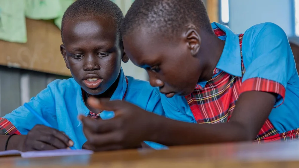 Estudiantes refugiados procedentes de Sudán del Sur estudian en Light Academy, en Kalobeyei, un centro educativo gestionado por la organización liderada por personas refugiadas KI4BLI. © ACNUR/Charity Nzomo