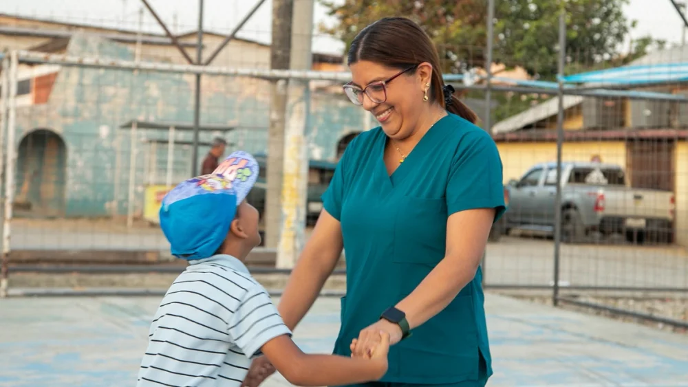 Anghie llegó desde Venezuela con la decisión de seguir haciendo lo que sabía hacer mejor: escuchar, acompañar y enseñar. Desde su nueva comunidad en Guayaquil, ella ha convertido el refuerzo escolar en un camino para la confianza y la construcción de comunidad desde el ejercicio de los derechos. © ACNUR/Bill Vargas