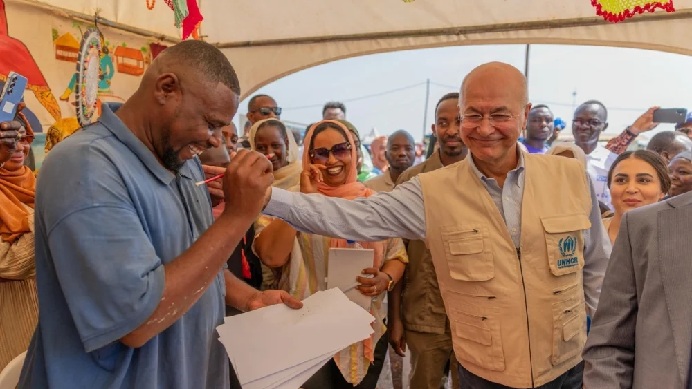 El artista refugiado sudanés Mohammed Ibrahim (izquierda) dibuja al Alto Comisionado de las Naciones Unidas para los Refugiados, Barham Salih (derecha), en el asentamiento de refugiados de Ura, en Etiopía. © ACNUR/Charity Nzomo