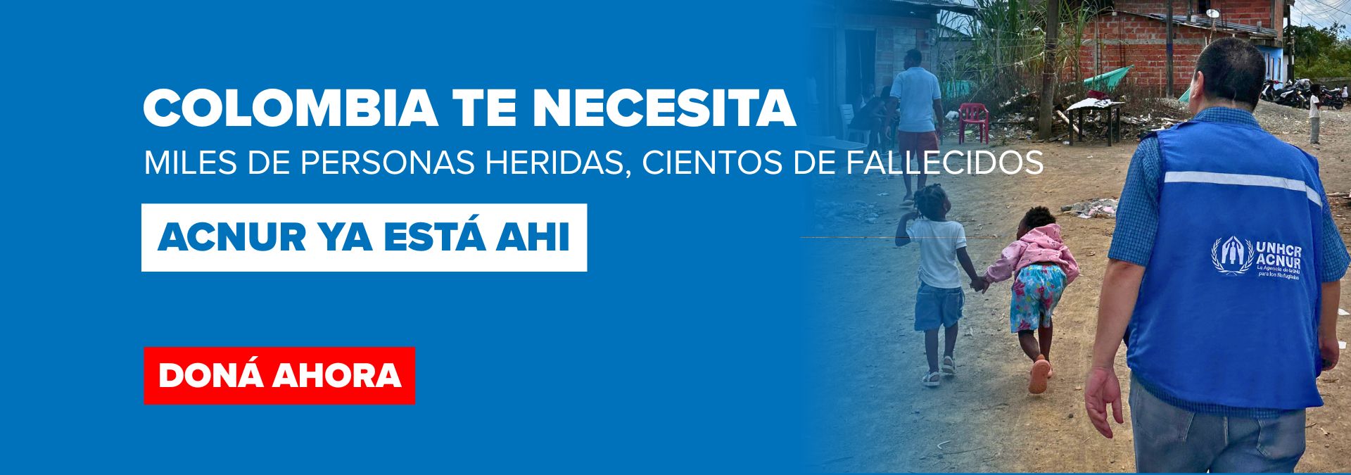 Banner urging donations for Colombia: Spanish text about injured and dead; UNHCR aid worker in a blue vest guiding two children along a dirt road.
