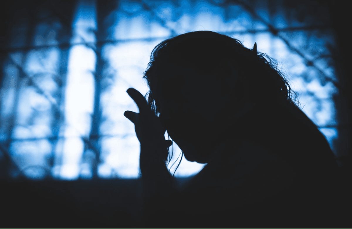 Silueta de una mujer a contraluz frente a una ventana