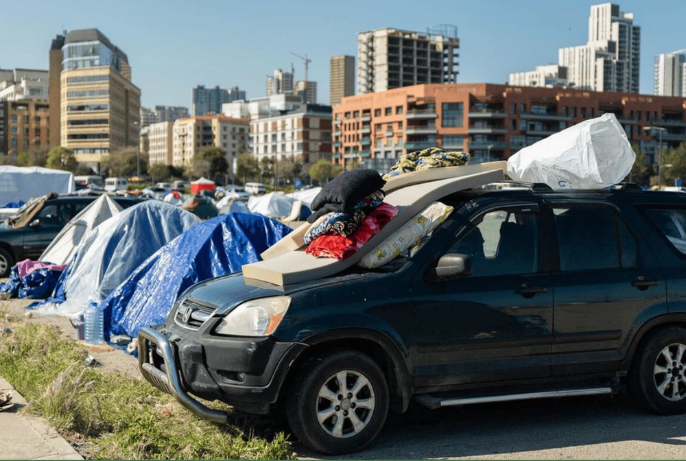 Carpas y un auto cargado con colchones y pertenencias en una ciudad del Líbano