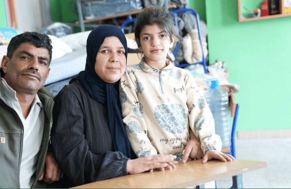 Una familia desplazada sentada en un aula convertida en refugio