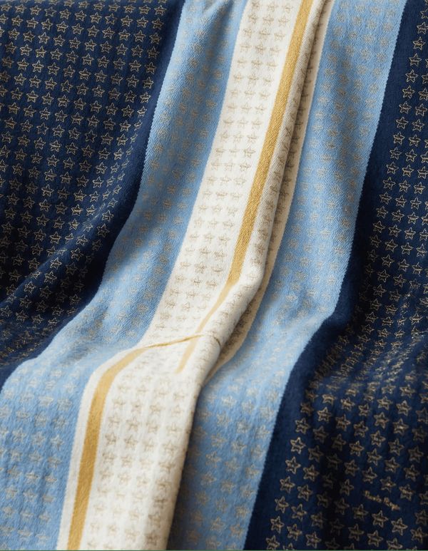El Poncho del Millón de Estrellas, con estrellas bordadas en celeste, blanco y azul