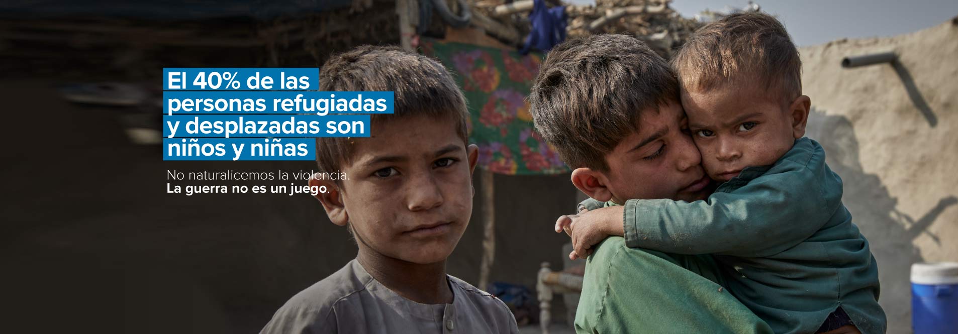 Rahatullah, de 8 años, carga a su hermano menor Nauman, de 2 años, enfermo, en su hogar temporal en Jalalabad, Afganistán.